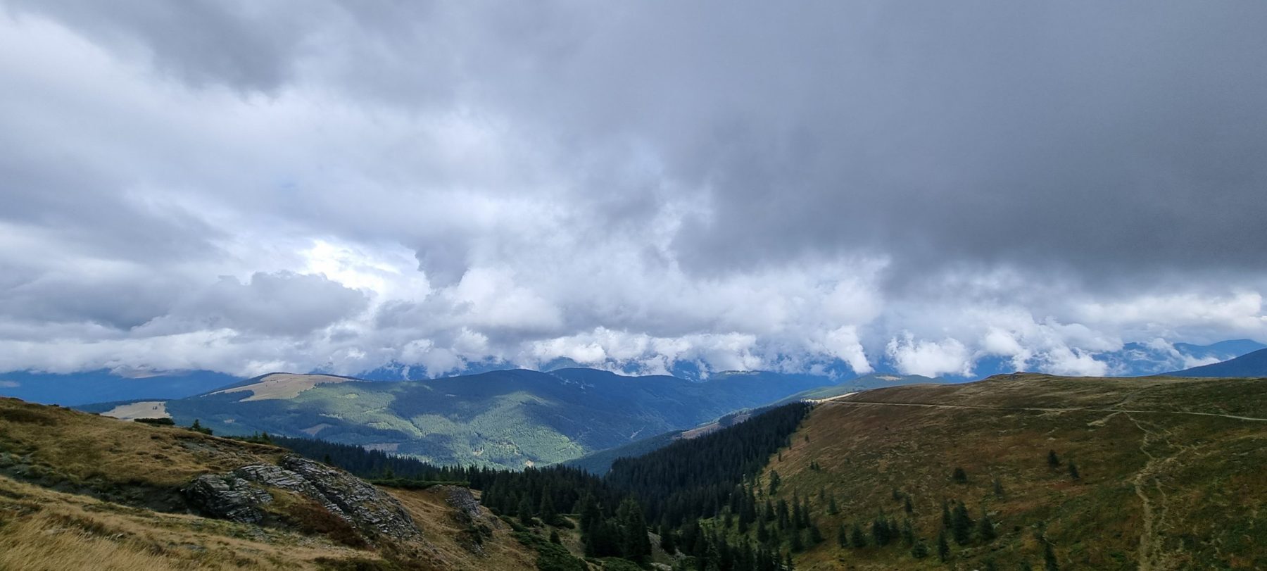 Clouds rolling over forested ridges along the Strategica ridge road